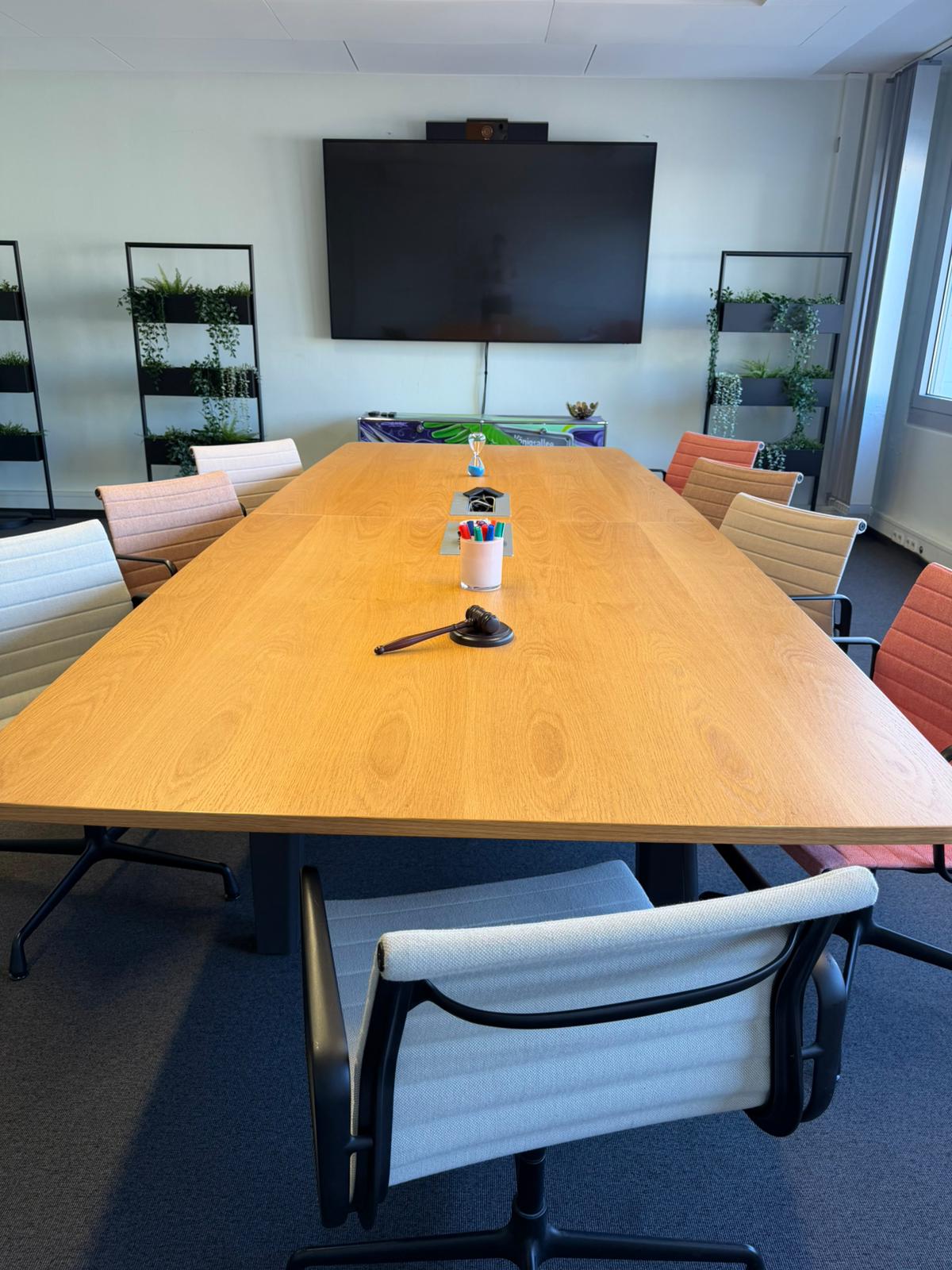 Der Executive Meeting Space mit einem höhenverstellbaren Holztisch, ergonomischen Stühlen und einer separaten Lounge-Ecke für Breakout-Sessions